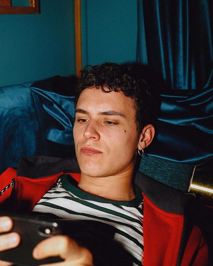 Arón Piper relaxed and focused on phone in cozy setting natural candid portrait wallpaper