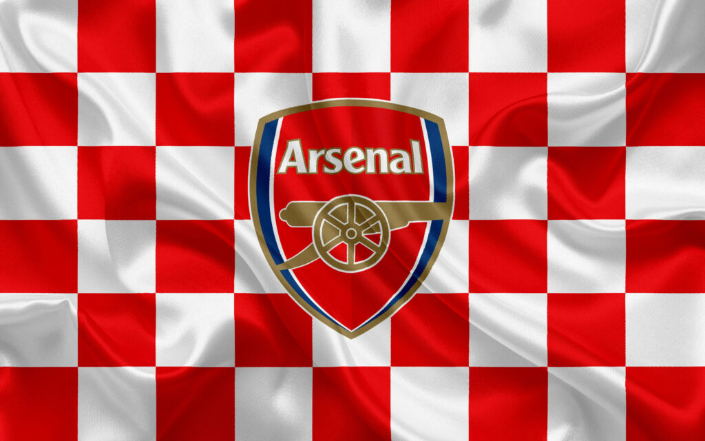 Arsenal FC crest on red and white checkered flag wallpaper symbolizing club spirit and tradition