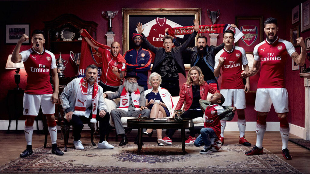 Arsenal FC players and fans united in a trophy room showcasing team spirit and pride wallpaper