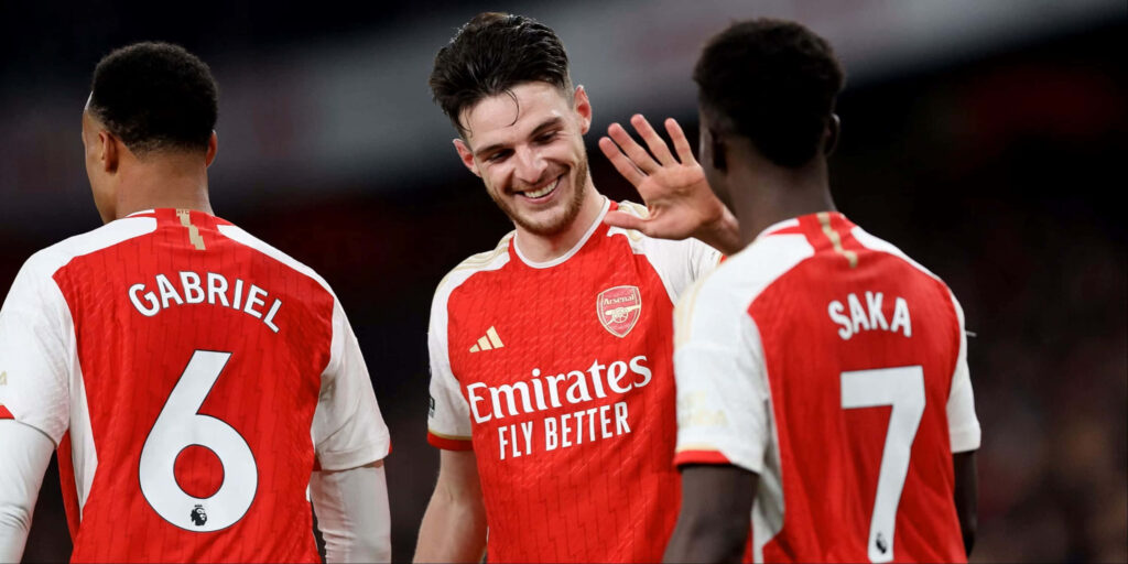 Arsenal football stars Declan Rice Gabriel Magalhaes and Bukayo Saka celebrating on pitch Wallpaper