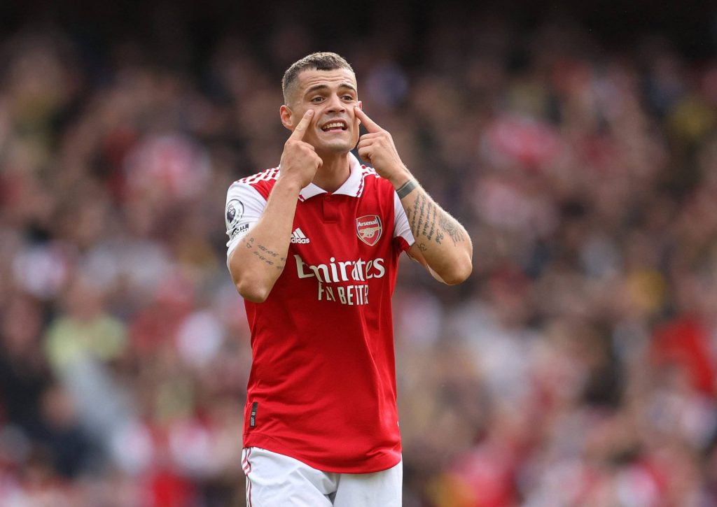 Arsenal Granit Xhaka in red kit pointing to eyes mid-match stadium background wallpaper