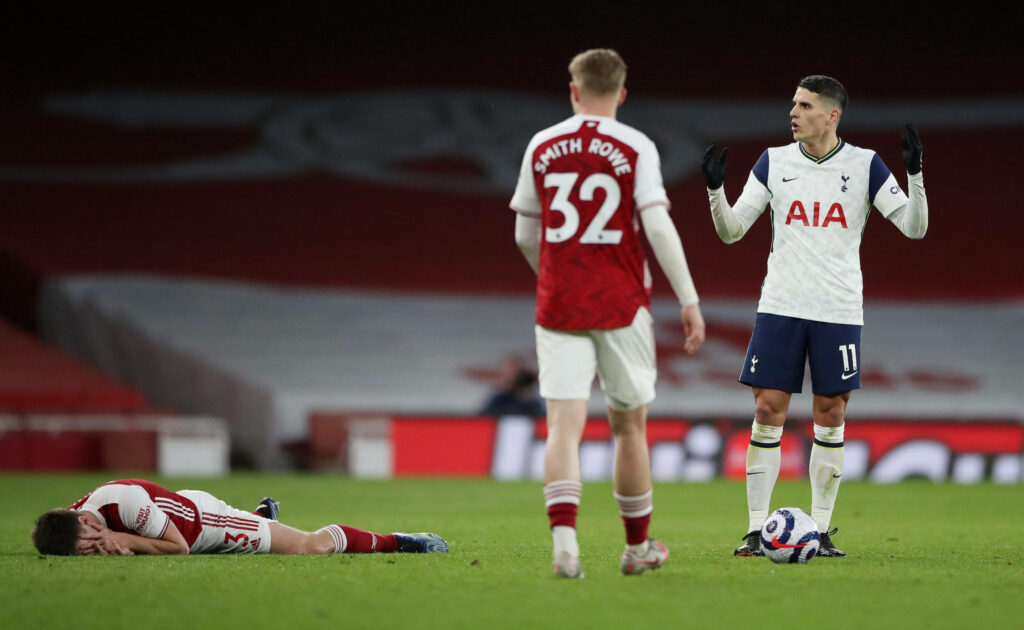 Martin Ødegaard on pitch with Emile Smith Rowe and Erik Lamela during intense Arsenal Tottenham match Wallpaper