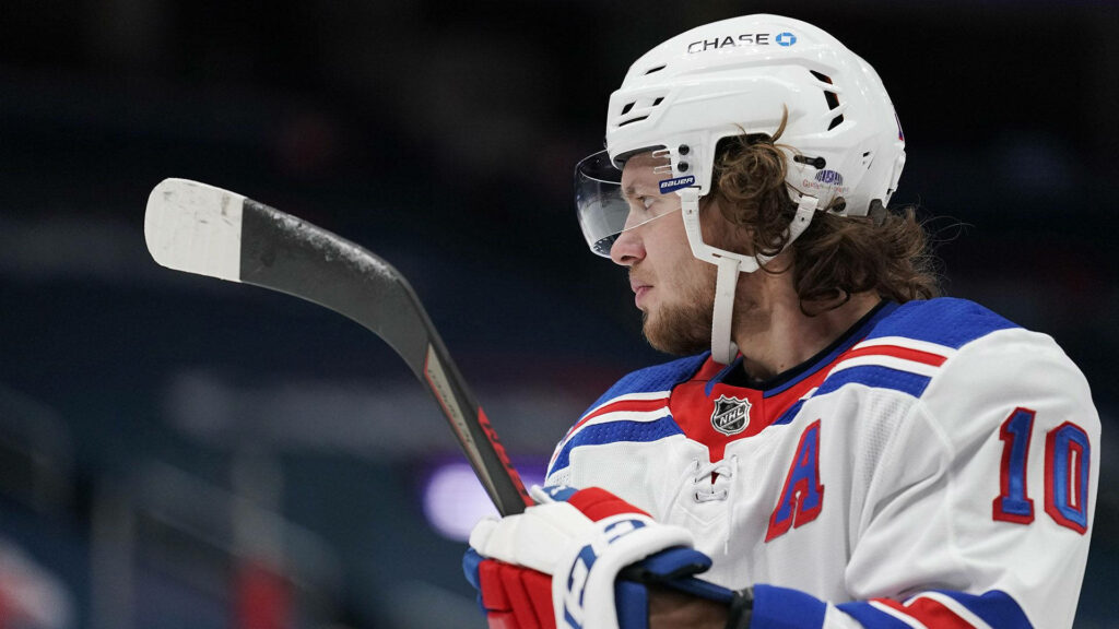 Artemi Panarin in New York Rangers uniform holding hockey stick focused on game wallpaper background