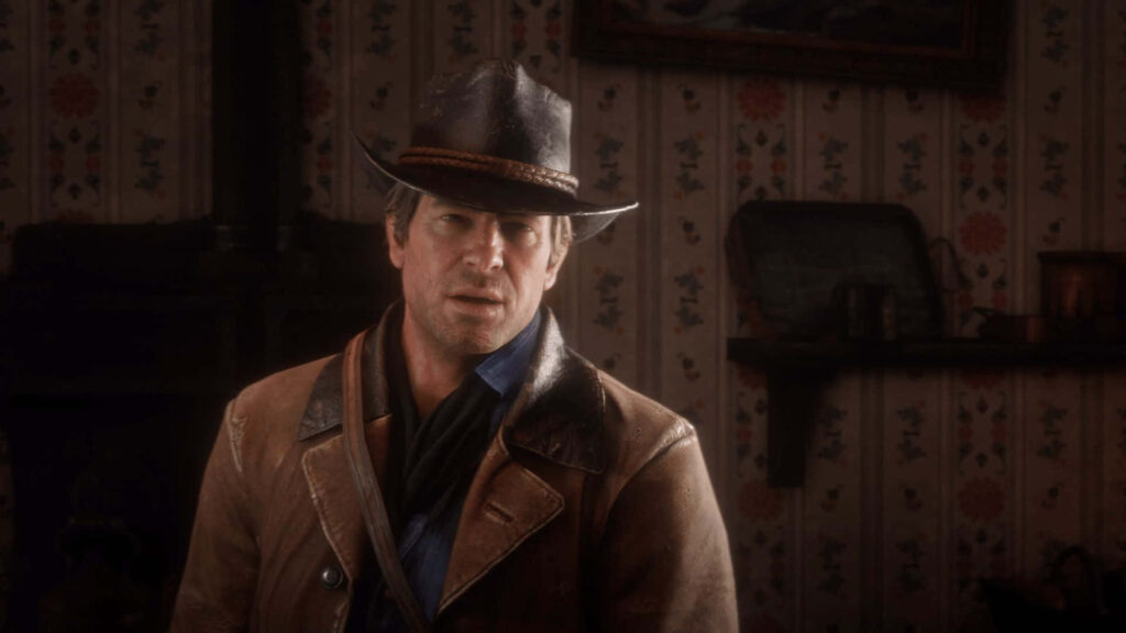 Arthur Morgan indoors in Red Dead Redemption 2 wallpaper wearing cowboy attire in warm light
