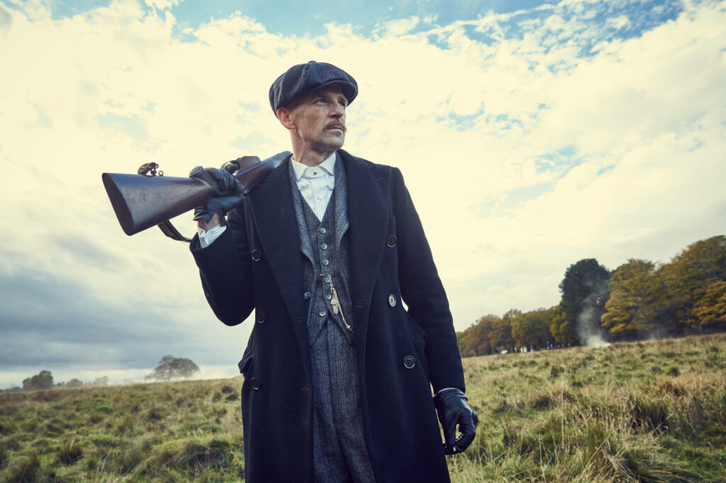 Gritty Arsenal: Arthur Shelby Enthralls with a Gun in this Stunning Peaky Blinders 8k Wallpaper