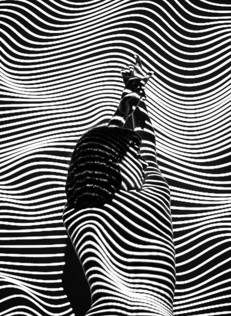 Dynamic Black and White Wallpaper: Silhouette Against Wave Pattern