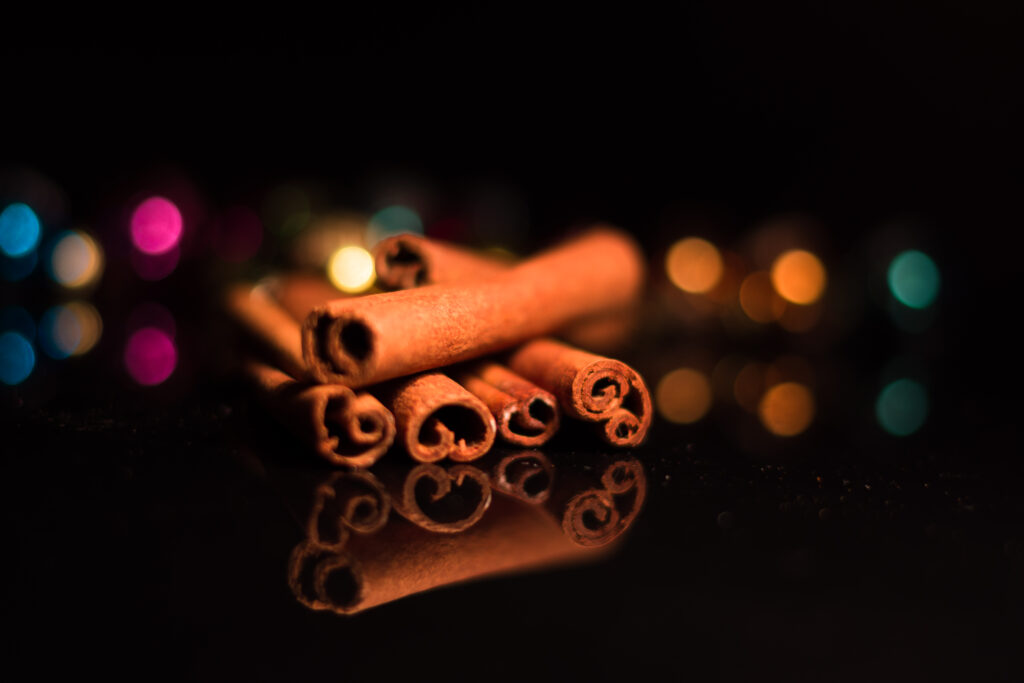 Artistic Cinnamon Sticks Wallpaper on Glossy Black Surface