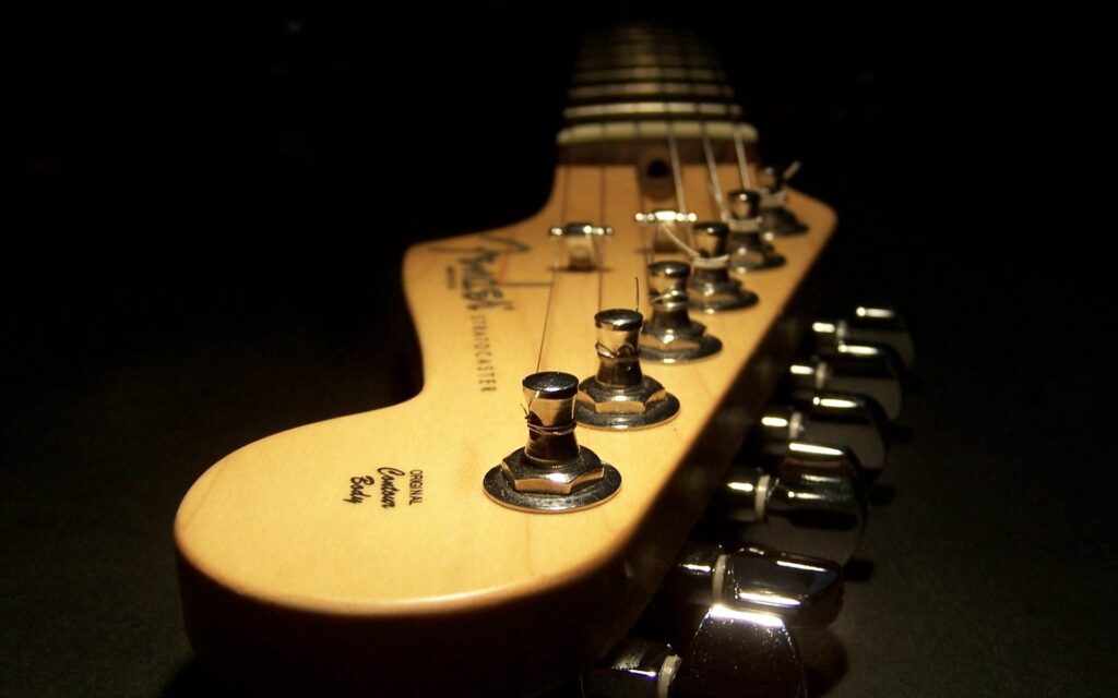 Artistic Guitar Headstock Close-Up with Tuning Pegs - Dark Wallpaper