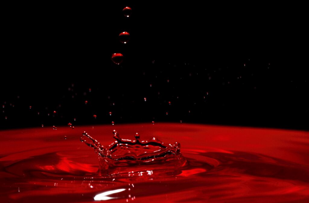 Vivid Red Splash: Macro Water Droplet Reflections Wallpaper