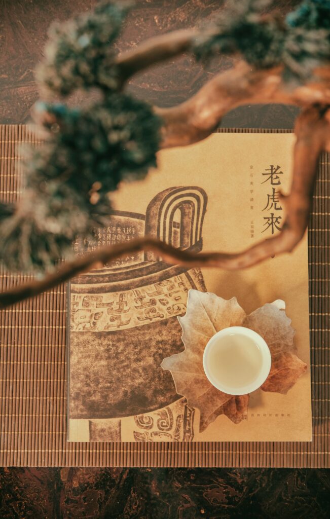Artistic Wallpaper: Cup on Textured Surface with Hieroglyphs & Leaves