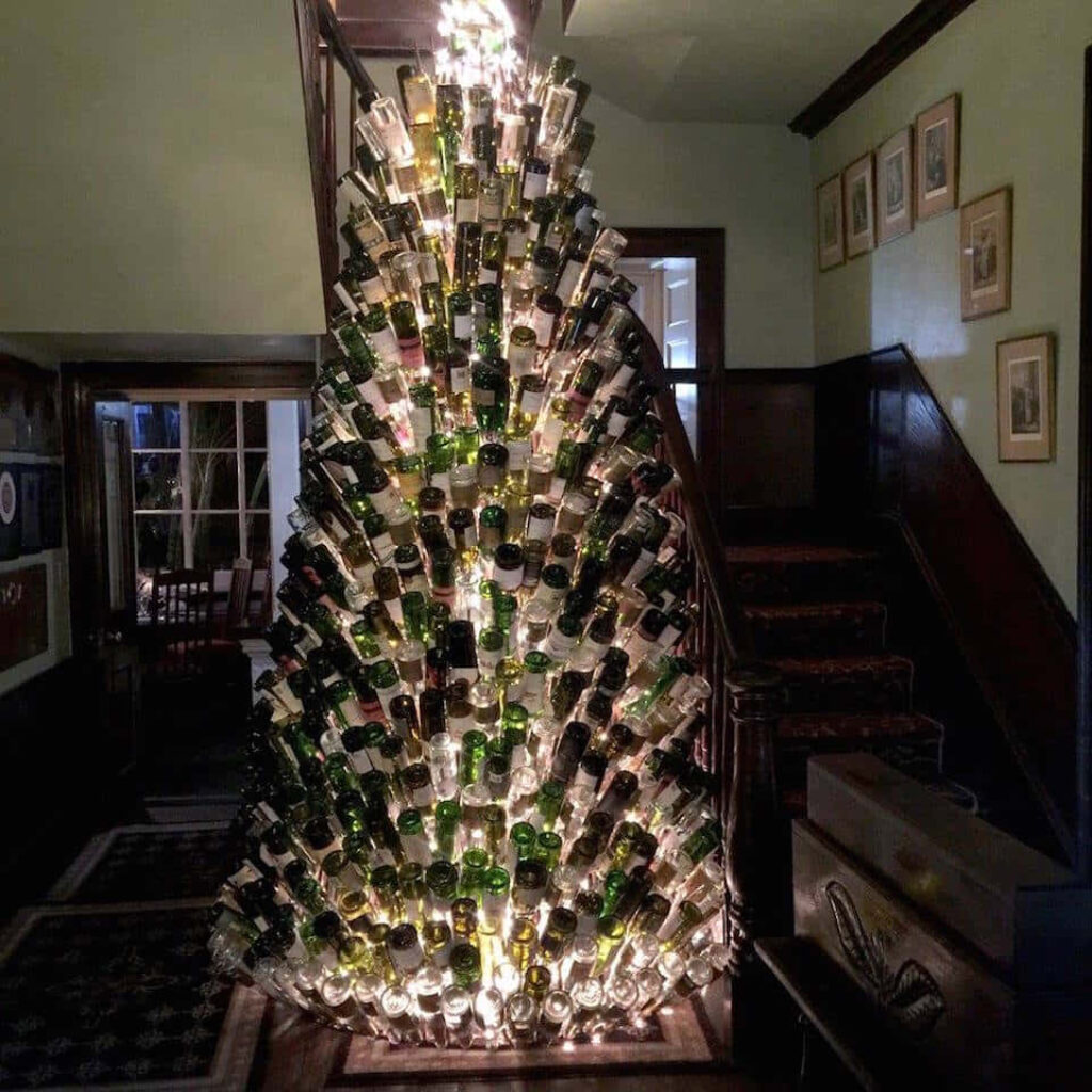 Artistic Christmas Tree Made of Stacked Wine Bottles - Festive Decor Wallpaper