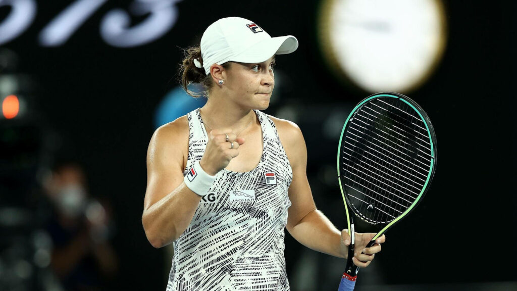 Ashleigh Barty celebrates victory holding black green tennis racket on vibrant court wallpaper background