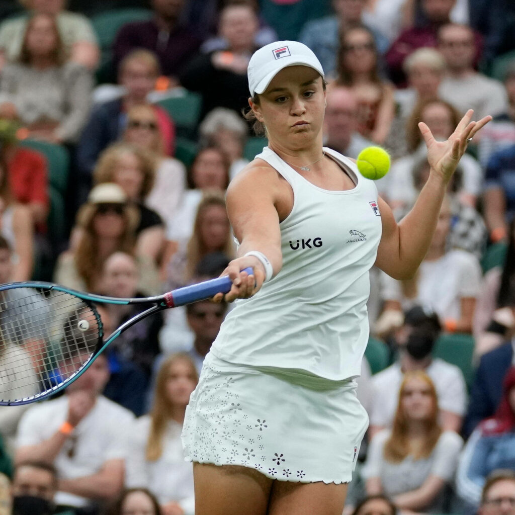 Ashleigh Barty hitting a forehand shot in tennis match with focused audience in background Wallpaper