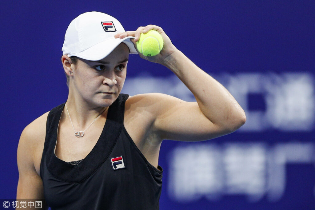 Ashleigh Barty focused on tennis court adjusting cap preparing to serve in competitive match wallpaper