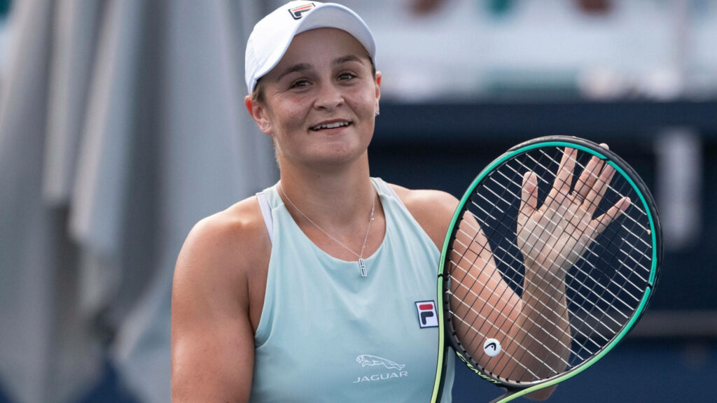 Ashleigh Barty smiling and waving with tennis racket on court showcasing champion spirit wallpaper