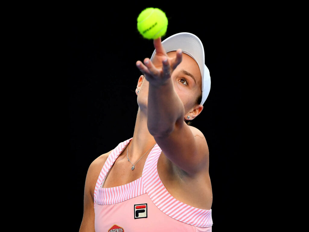 Ashleigh Barty focused serving tennis ball during match showcasing determination and skill wallpaper