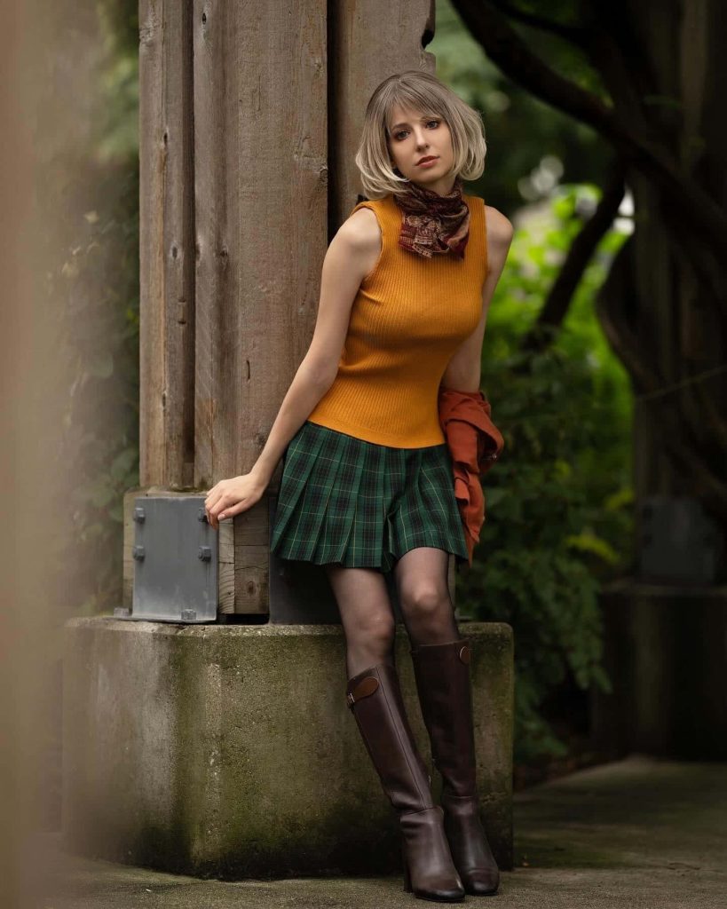 Woman in Ashley Graham Resident Evil 4 cosplay yellow top green plaid skirt brown boots outdoors Wallpaper
