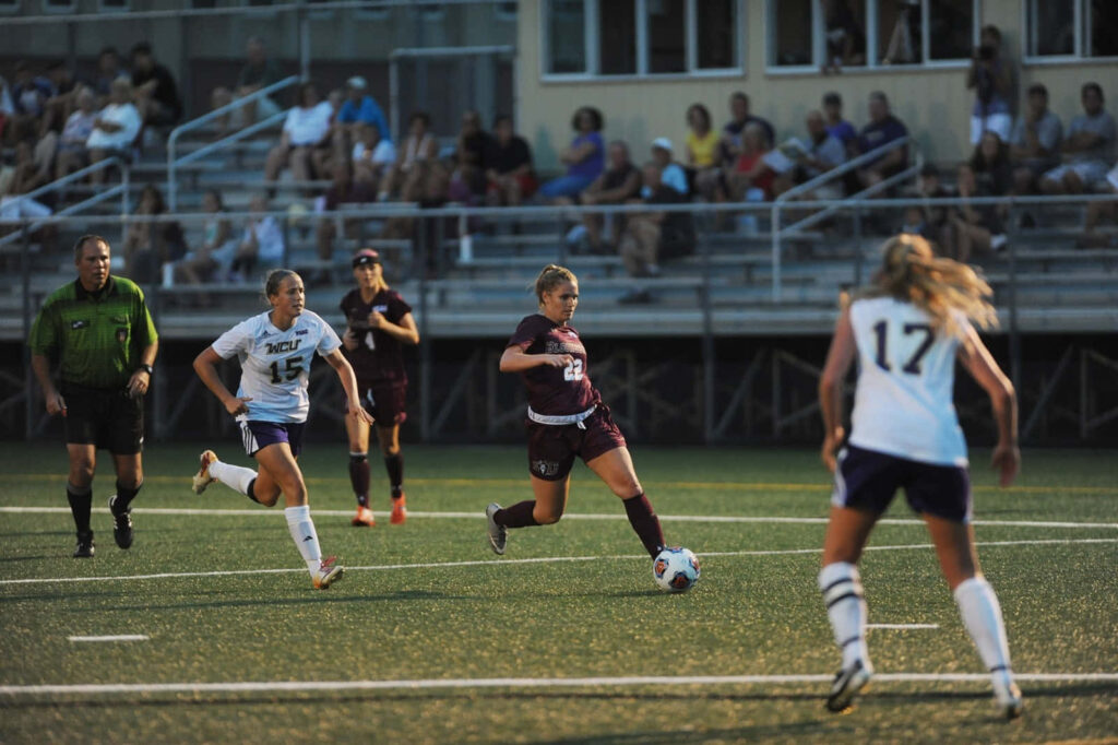 Ashley Sanchez dribbling soccer ball past defenders showing focus determination wallpaper