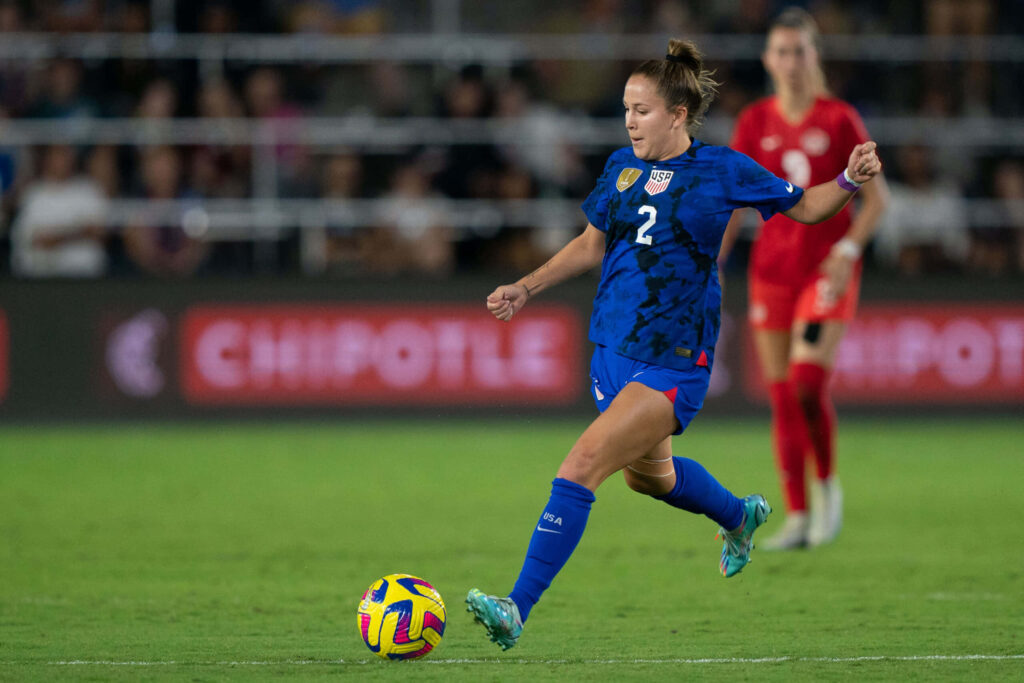 Ashley Sanchez skillfully controls soccer ball mid-action during competitive match vibrant wallpaper