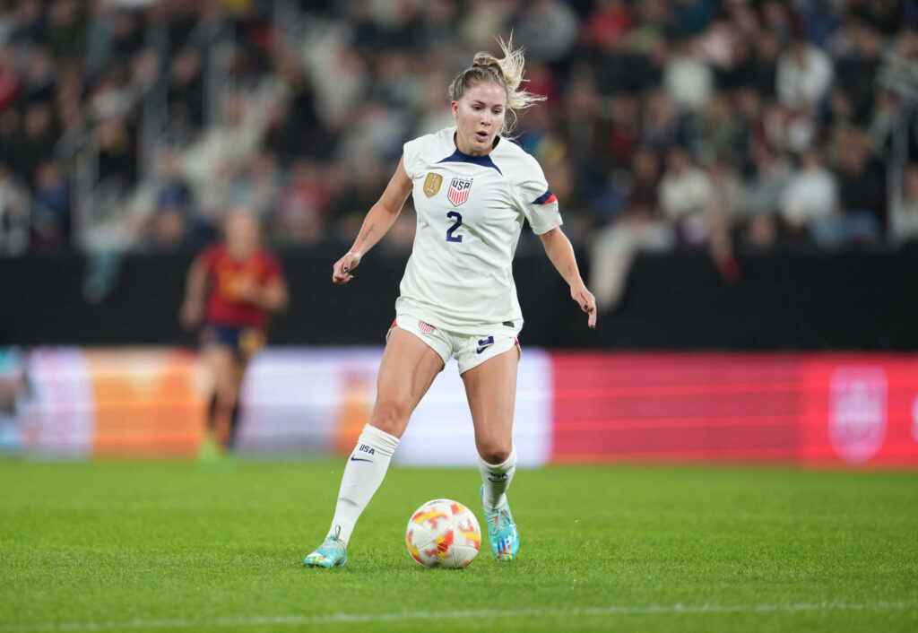 Ashley Sanchez USWNT soccer player controlling ball in match with blurred stadium crowd background Wallpaper