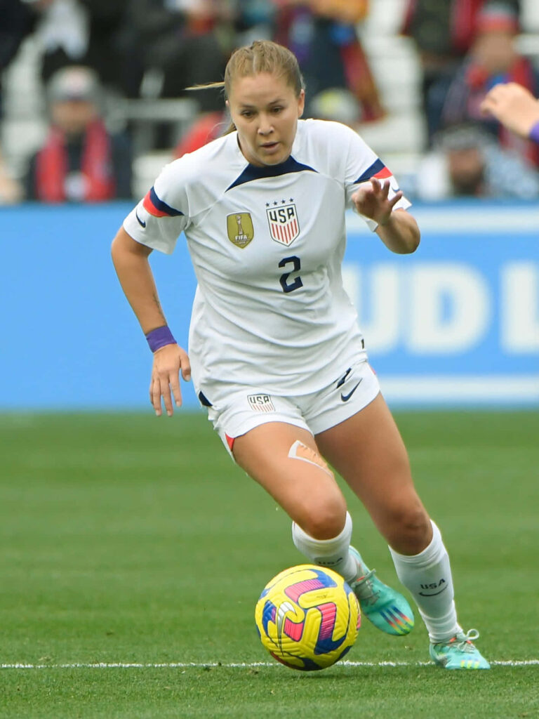 Ashley Sanchez in USA soccer kit focused on controlling ball during match action wallpaper