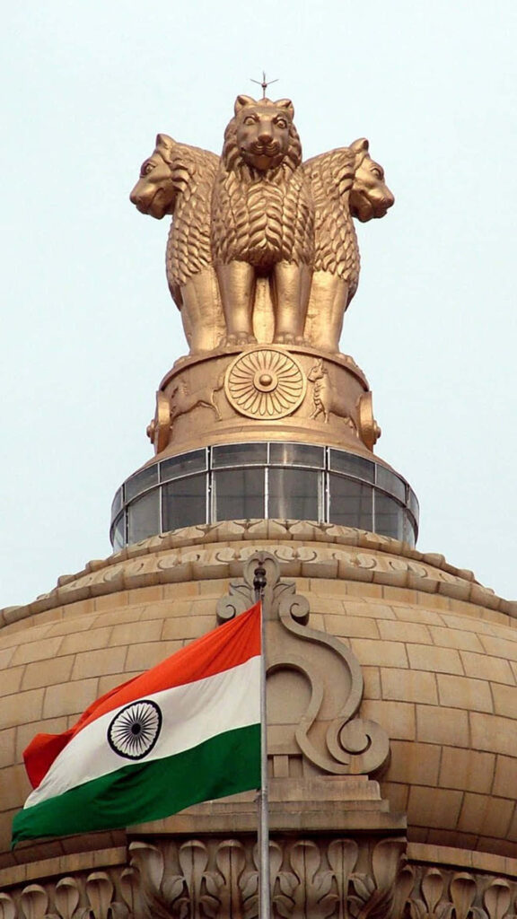 Ashoka Pillar with Indian national emblem above fluttering Indian flag wallpaper background