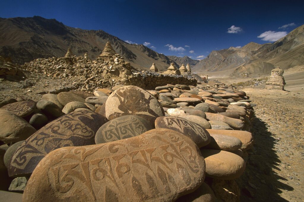 Asian mountain landscape with intricately patterned stones and traditional art in earthy tones Wallpaper