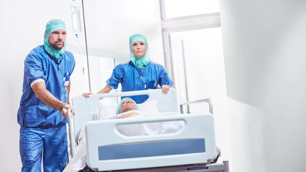 Medical Team Assisting Patient with Post-Op Urinary Complications: A Helping Hand in the Recovery Journey Wallpaper