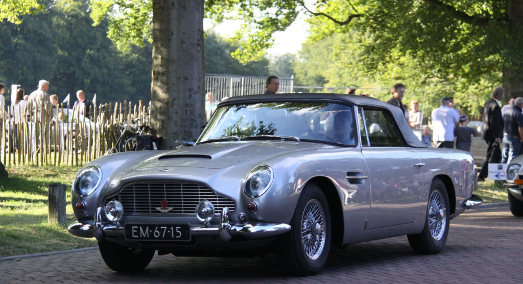 Aston Martin DB5 classic silver car in natural sunlight with timeless design wallpaper background