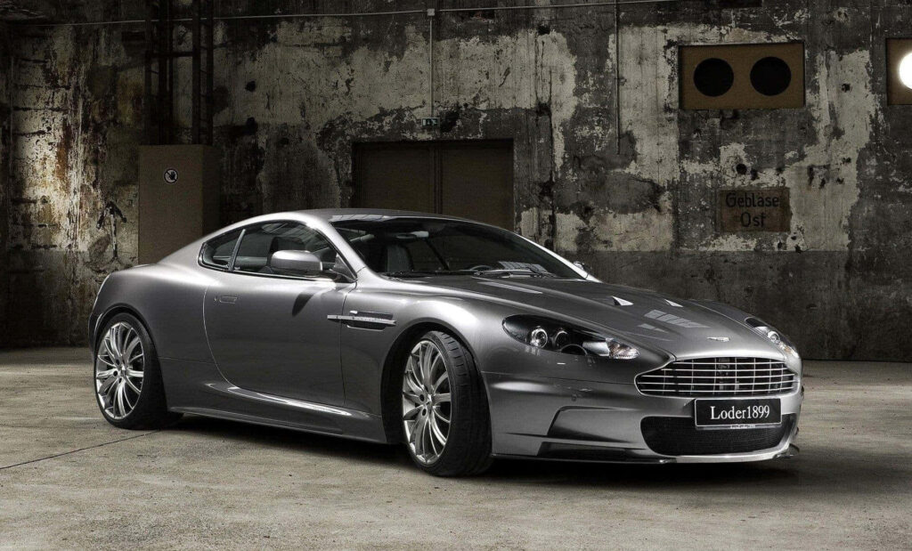 Aston Martin DB9 luxury sports car in industrial setting showcasing elegant design and power Wallpaper
