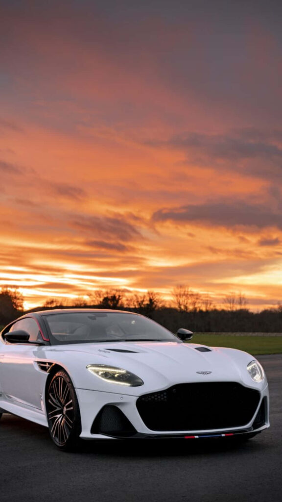 Aston Martin DBS Superleggera parked at sunset with sleek design and dramatic sky background Wallpaper