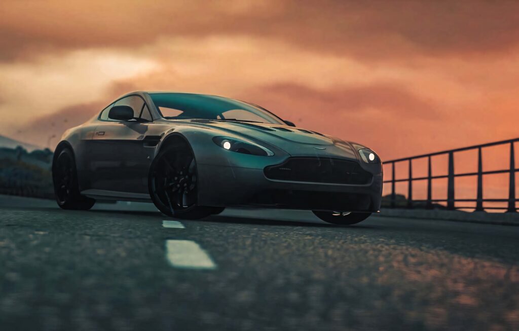 Aston Martin V12 Vantage luxury sports car on open road at sunset high-performance wallpaper background