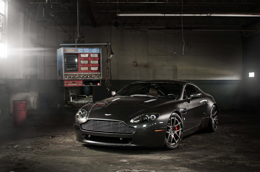 Aston Martin V12 Vantage in dim industrial setting highlighting bold design and power wallpaper