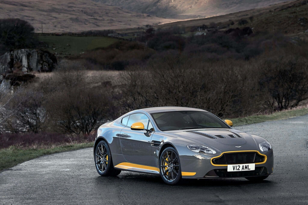 Aston Martin V12 Vantage parked on open road with rugged countryside scenic background wallpaper