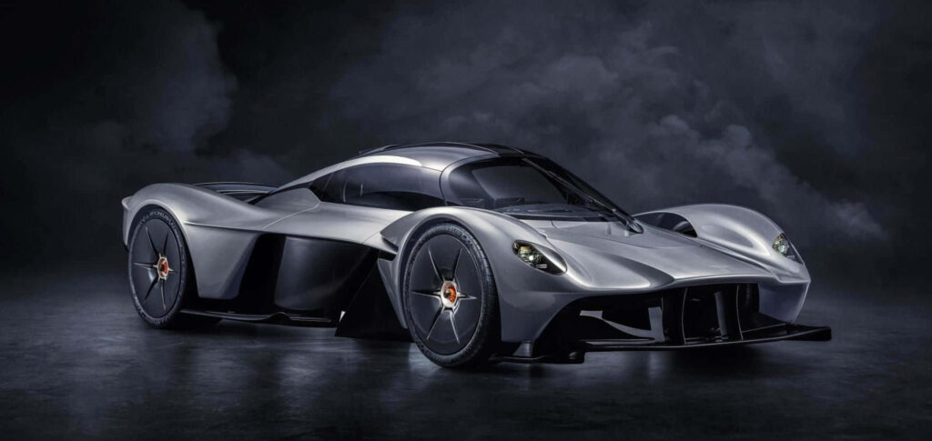 Sleek Aston Martin Valkyrie racing with aerodynamic curves on a dramatic dark wallpaper background