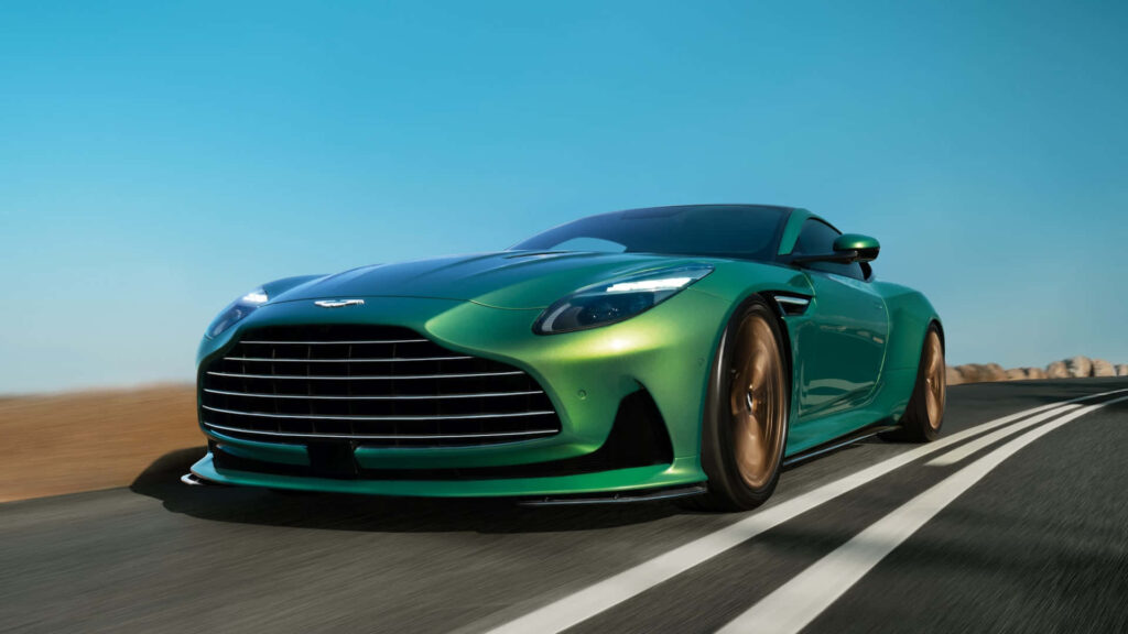 Aston Martin Vantage in bold green speeding on open road under clear blue sky wallpaper background