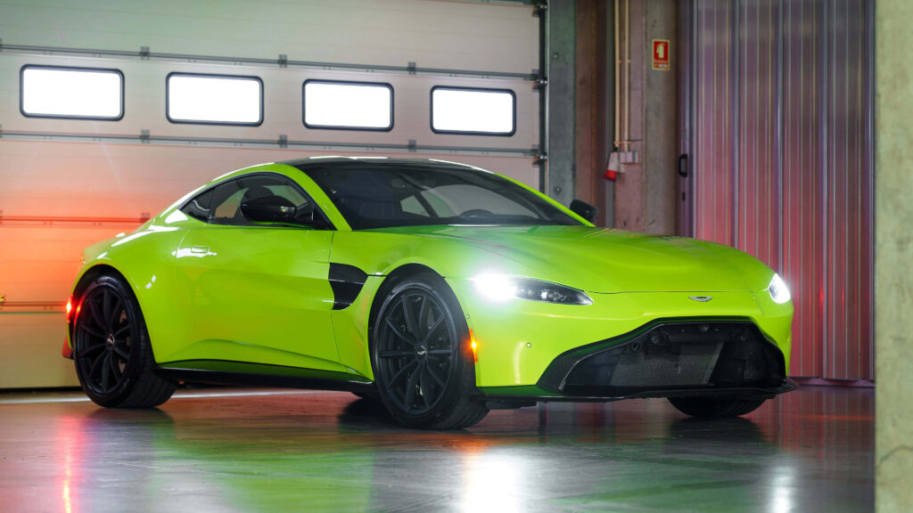 Aston Martin Vantage vibrant green sports car parked in sleek garage showcasing dynamic design Wallpaper