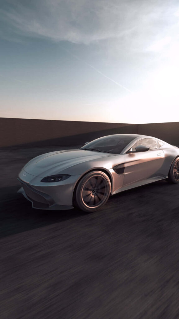 Aston Martin Vantage speeding on empty road clear skies aerodynamic sleek design wallpaper