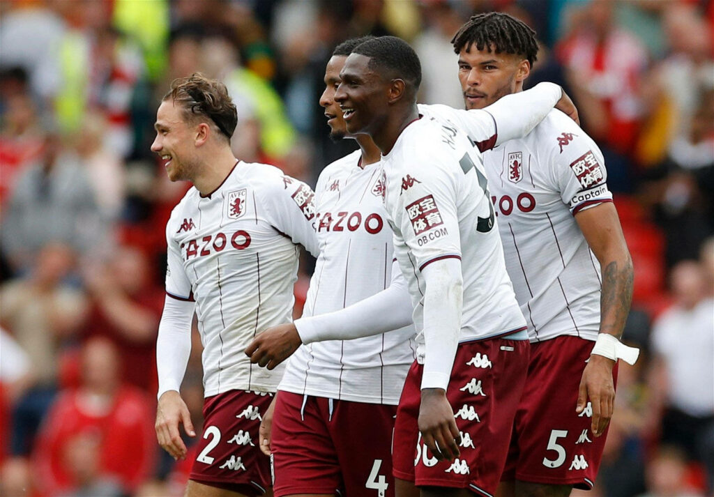 Aston Villa FC players smiling and celebrating unity on the field during an exciting match wallpaper
