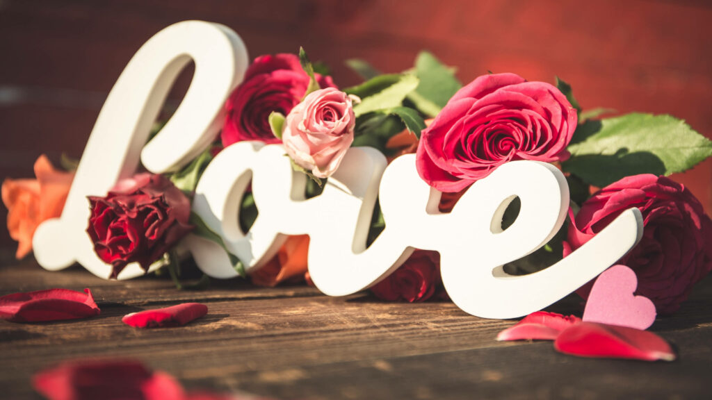 Mesmerizing Love: A Captivating Full 4k Background Photo adorned with Rose-inspired White Cursive Typography and Heart Shapes. Wallpaper