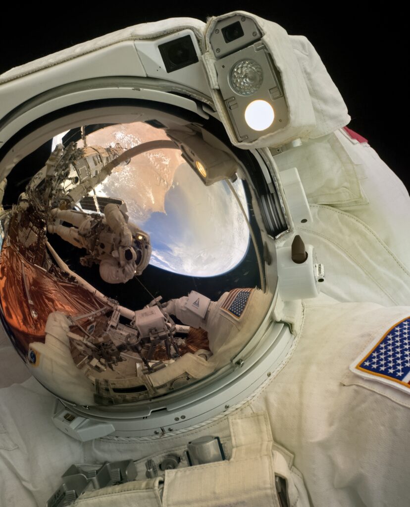 Astronaut Reflection Wallpaper: Stunning View of Earth & Space Station