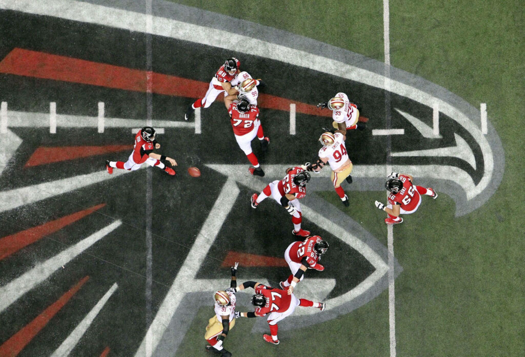 Aerial view of Atlanta Falcons football players in action on the field with team logo visible Wallpaper