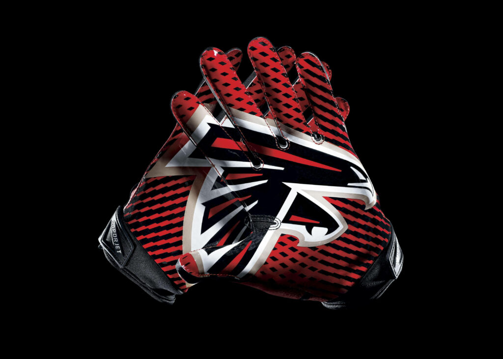 Close-up of red and black Atlanta Falcons football gloves forming team logo on dark background Wallpaper