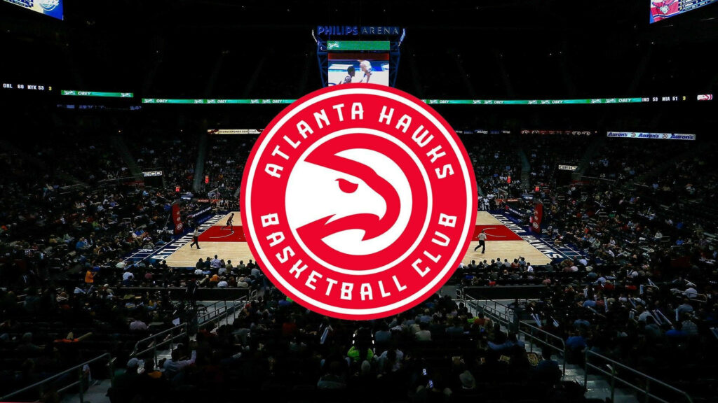 Atlanta Hawks logo centered on basketball court with lively game atmosphere background wallpaper