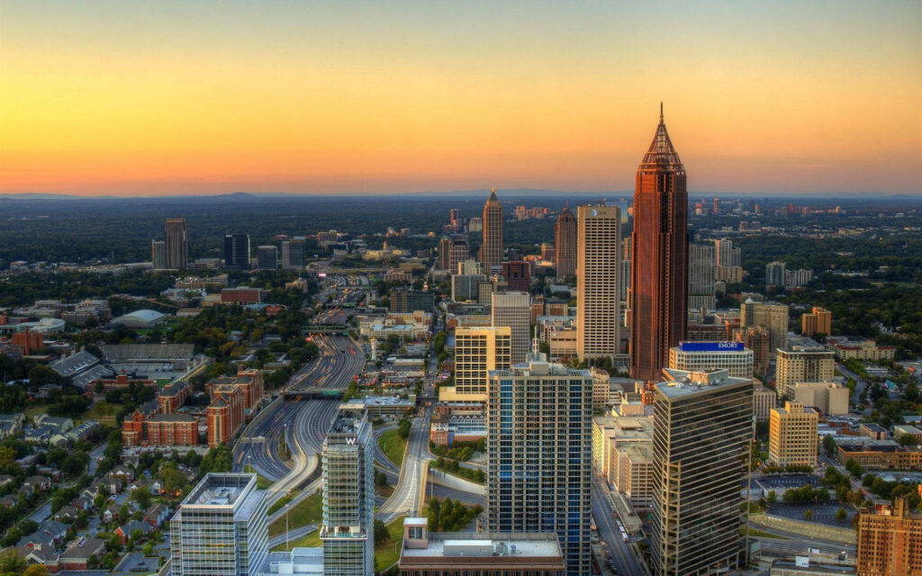 Atlanta skyline at sunset with warm orange hues highlighting iconic skyscrapers wallpaper