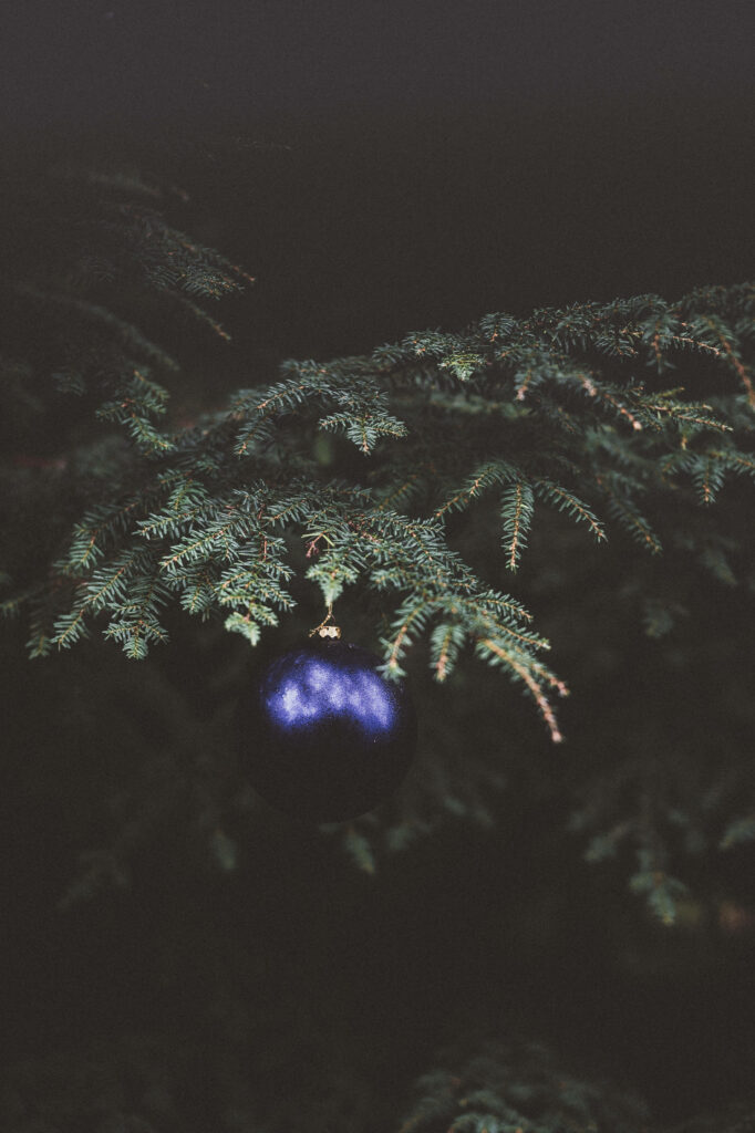 Enchanting Dark Christmas Wallpaper with Luminous Blue Ornament