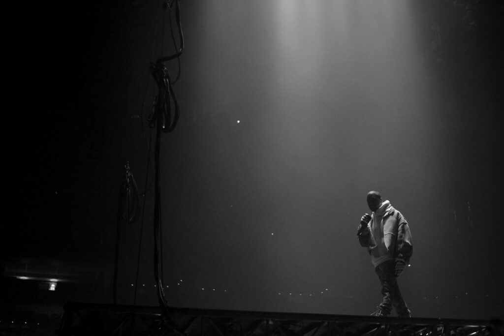 Dramatic Grayscale Wallpaper of Performer on Dimly Lit Stage