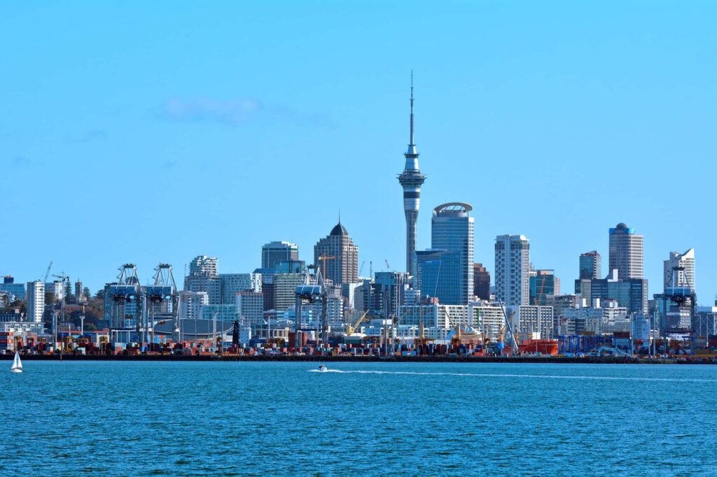 Auckland skyline with Sky Tower under blue sky across sparkling harbor cityscape wallpaper