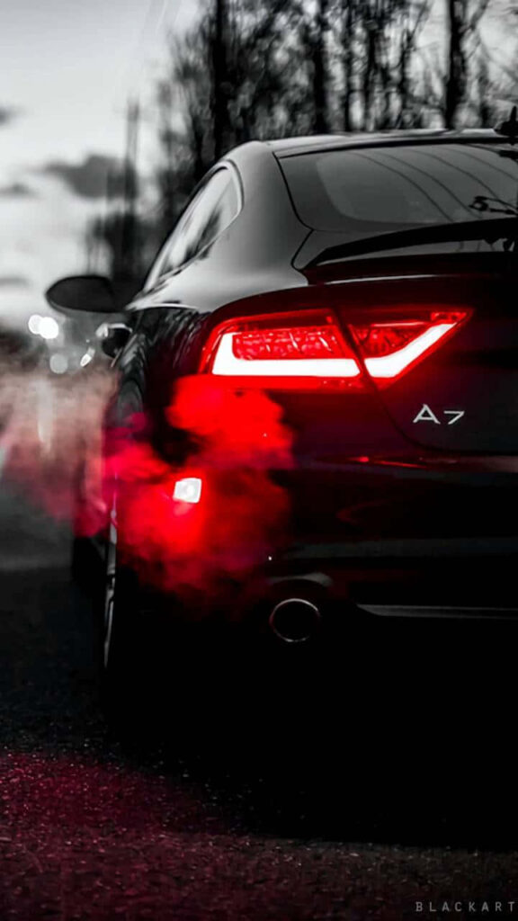 Sleek Audi A7 with glowing red brake lights against dark moody background modern design wallpaper