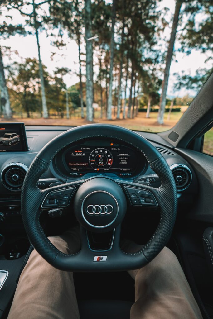 Audi Interior Wallpaper: Steering Wheel & Speedometer in Forest View